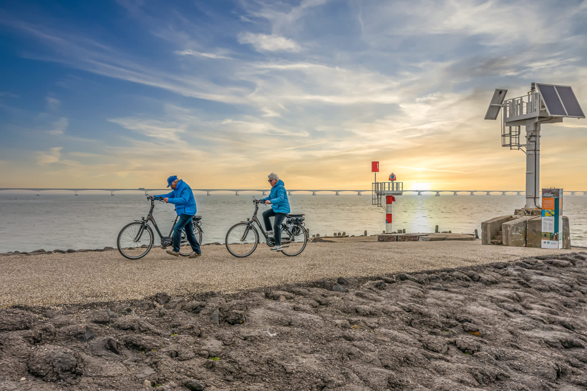 Fietsen langs de kust bij zonsondergang Zeeland